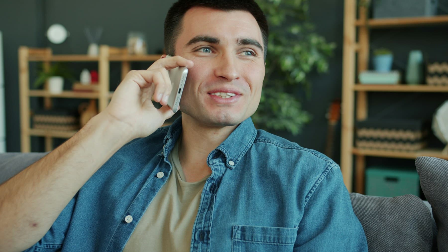 An adult enjoying a relaxed phone conversation at home